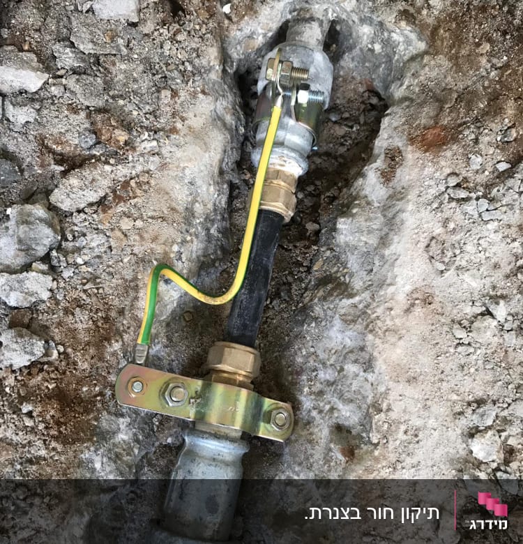 צינור מתכת עם חיבורי ברזל ואדמה חשופה